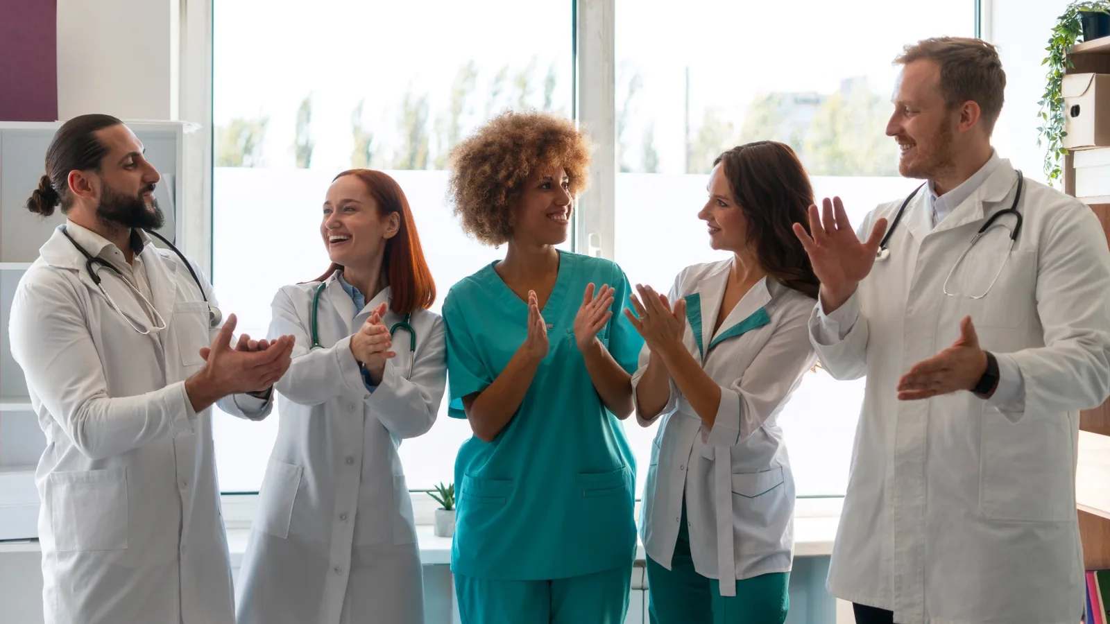 Une équipe de soignants qui applaudit dans un cabinet lumineux